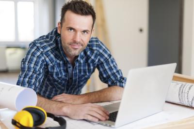 Builder On Laptop In Office